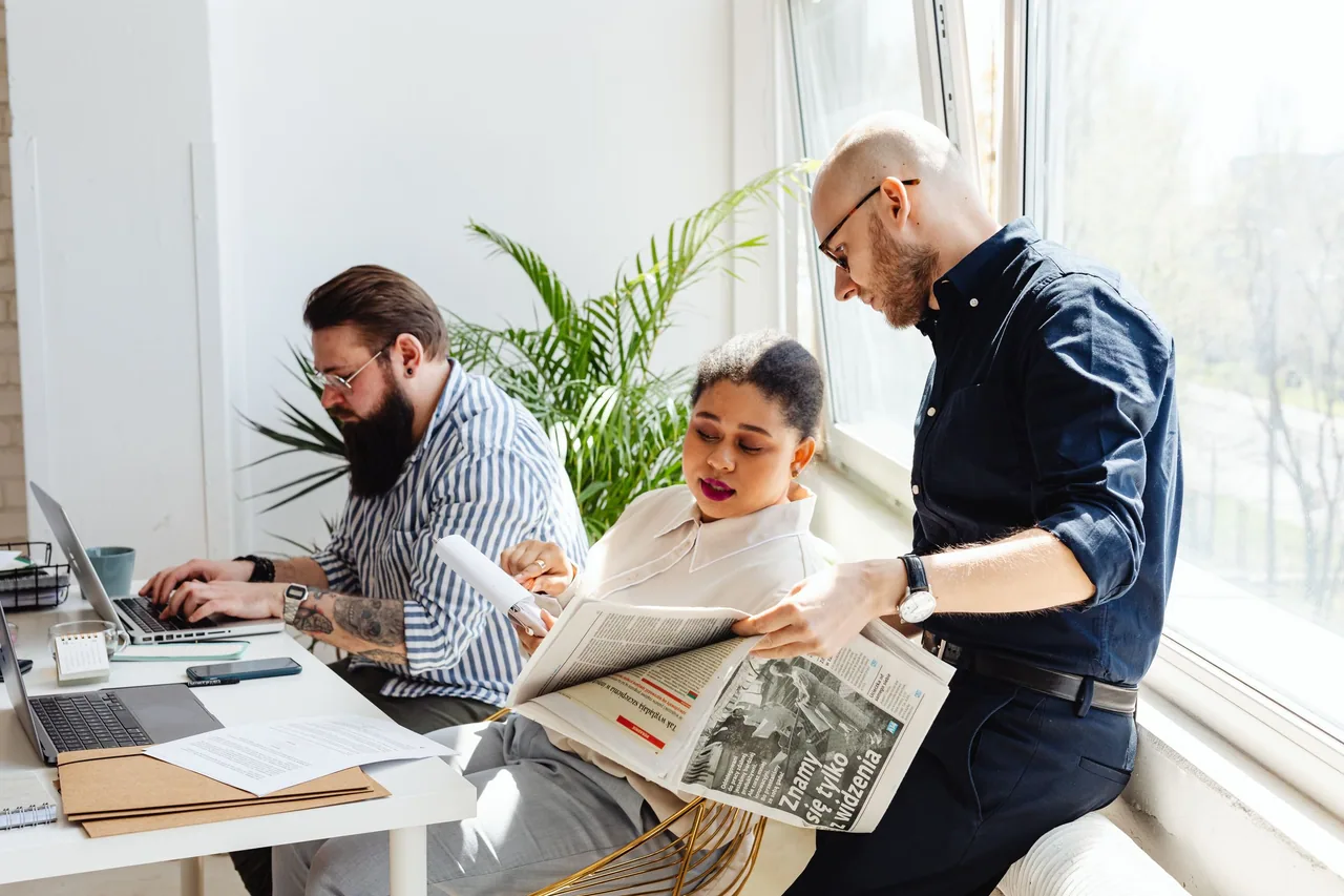 An editorial team discussing a document together