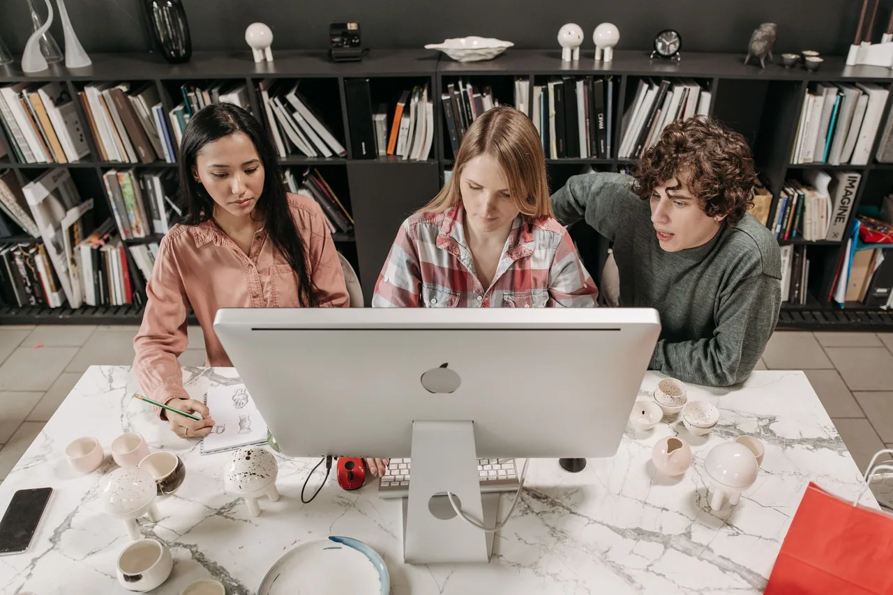 An editorial team reviews the finished work together at a screen