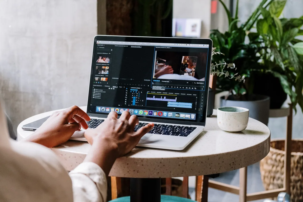 An editor works with a video timeline on a laptop